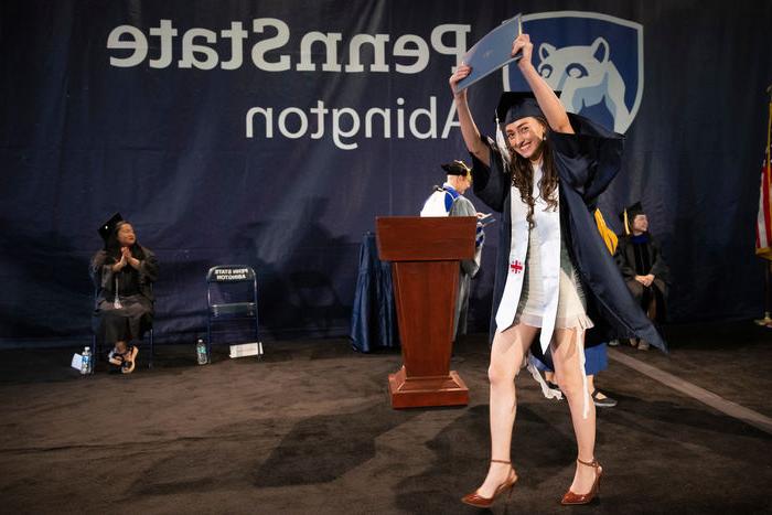 student holding her diploma in the air